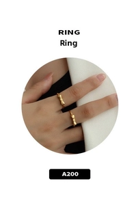 Detail of gold minimalist bow rings worn on fingers with a white circular frame