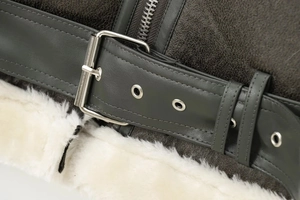 Detail of cracked brown leather jacket with silver buckle and white shearling lining