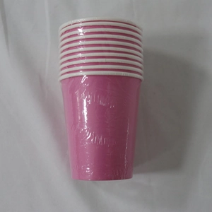 Stack of pink disposable paper cups wrapped in clear plastic on white fabric