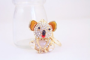 Detail of a sparkling koala keychain with rhinestones and colorful enamel on a gold chain