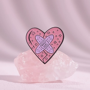 Detail of pink enamel heart brooch with Broken Heart text on a crystal base