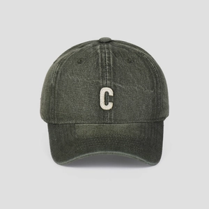 Macro detail of embroidered C patch on a vintage washed denim baseball cap with fine stitching