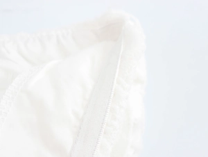 Vue macro détaillée de la bande élastique et des coutures de la robe en dentelle blanche