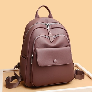 Purple soft leather women's backpack with multiple pockets and silver hardware on a beige background