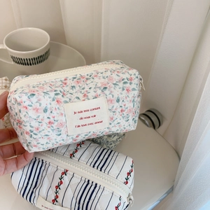 Close-up of floral and cherry quilted cotton pouches on a tray with natural lighting