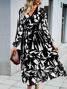 Detail of V-neck printed dress with black and white geometric pattern and ruffle hem