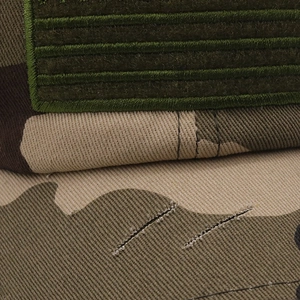 Detailed macro view of camo tactical baseball cap showing stitching and velcro patch area