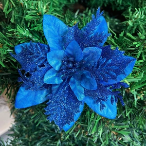 Close-up of blue glittered artificial poinsettia flower on a Christmas tree branch