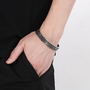 Macro detail of men's Viking rune bracelet with Valknut symbol and oxidized finish