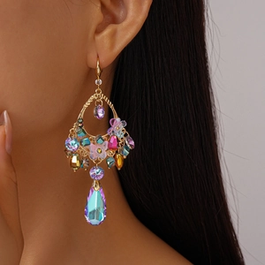 Detail of vintage gold earring with colorful crystals, flowers and purple teardrop gem