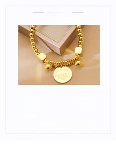 Macro detail of gold-plated titanium steel bracelet with engraved Eternal Love charm