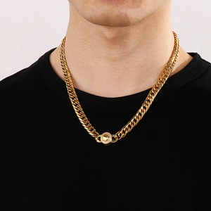 Detail of 9mm gold Cuban chain necklace with a diamond-encrusted circular clasp on a model