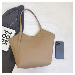 Dettaglio della borsa tote beige con grana litchi e tracolla sottile con fibbia
