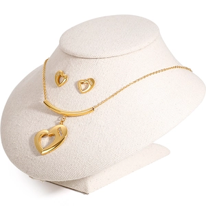 Golden stainless steel heart jewelry set with necklace and earrings on model stand