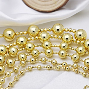 Elegant multi-layer golden bead necklace displayed on soft white silk and wood background