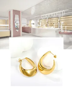 Detailed view of thick gold teardrop hoop earrings with high-polish mirror finish