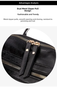 Detail of smooth golden two-way zipper with long leather pullers on black textured bag