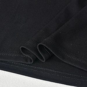 Detail of black ribbed knit fabric showing high-quality stitching and texture for women