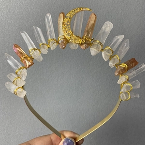Detail of handmade crown headband with yellow crystals and golden moon pendant accessory