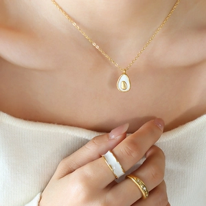 Minimalist avocado pendant necklace and gold enamel ring set shown on model