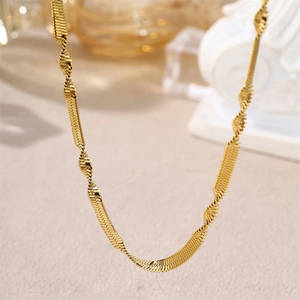 Minimalist gold snake bone chain necklace with twisted wavy texture and metallic luster