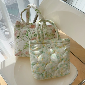 Quilted fabric tote bags featuring floral patterns and embroidered brand labels