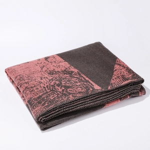 Detailed view of thick woven deer pattern shawl in grey and dusty pink fabric