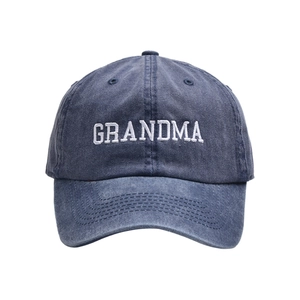 Detail of white GRANDMA embroidery on washed dark blue cotton canvas baseball cap