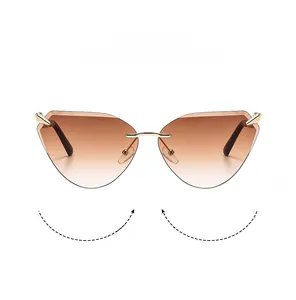 Detail of rimless cat eye sunglasses featuring brown gradient lenses and gold metal temples