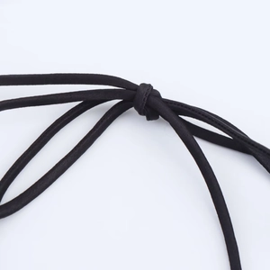 Close-up of black satin ribbon tie detailing on a long elegant fashion dress