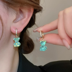 Vue détaillée de la boucle d'oreille ours résine vert clair avec créole dorée pavée