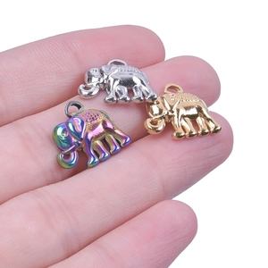 Three colorful elephant pendants in silver, gold, and rainbow finish on a hand