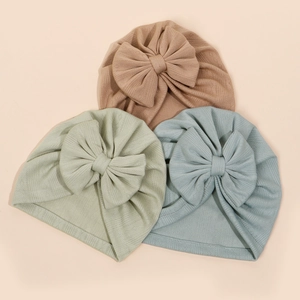 Trois bonnets turban pour bébé en tricot côtelé avec grands nœuds marron, vert et bleu