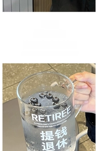 Detail of high borosilicate glass mug with thick handle and creative retiree printing