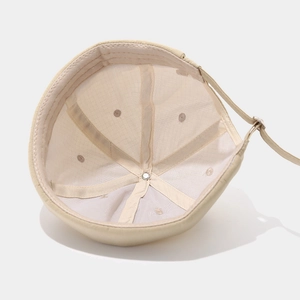 Interior view of beige docker cap with reinforced seams and adjustable metal buckle