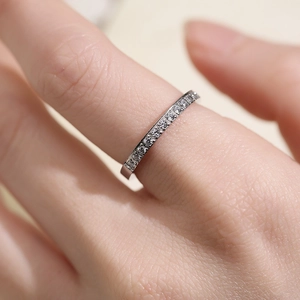Close-up of a silver titanium steel ring with sparkling paved diamonds on finger