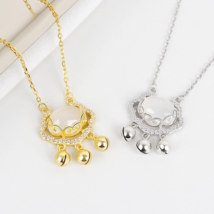 Detailed shot of gold and silver Ruyi Lock necklaces with chalcedony and small bells