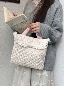 Close-up of quilted floral laptop bag with pink cotton handles and lace trim details