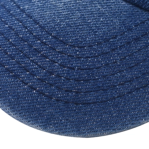 Detailed close-up of blue washed denim baseball cap brim with neat parallel stitching