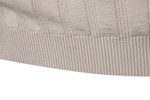 Makroaufnahme des Rippbündchens und der vertikalen Strickstruktur des beigen Polos