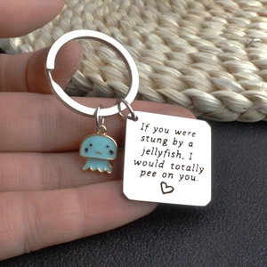Funny jellyfish friendship keychain with engraved stainless steel tag held in hand