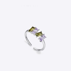 Macro view of adjustable silver ring featuring square green and purple zircon stones