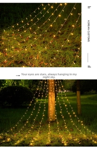 Warm yellow LED star waterfall lights decorating outdoor garden trees and lawn at night