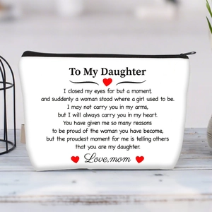 Close-up of white canvas pouch with sentimental text and red heart on wooden table