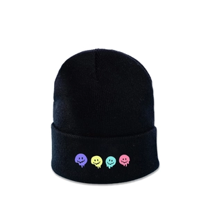 Dettaglio del berretto in maglia nera con quattro toppe smiley colorate per l'inverno