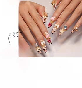 Macro detail of cartoon bear press-on nails with plaid patterns and 3D bow accents
