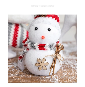 Detailed view of plush Christmas snowman figurine with knit hat and wooden snowflakes