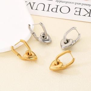 Détail de créoles en forme de U avec pendentif cœur en or 18 carats et acier poli