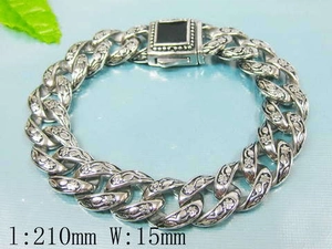 Detail of vintage silver Cuban chain bracelet with floral engraving and black gemstone clasp