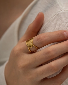 Detail of gold hollow irregular geometric ring with hammered texture on a model hand